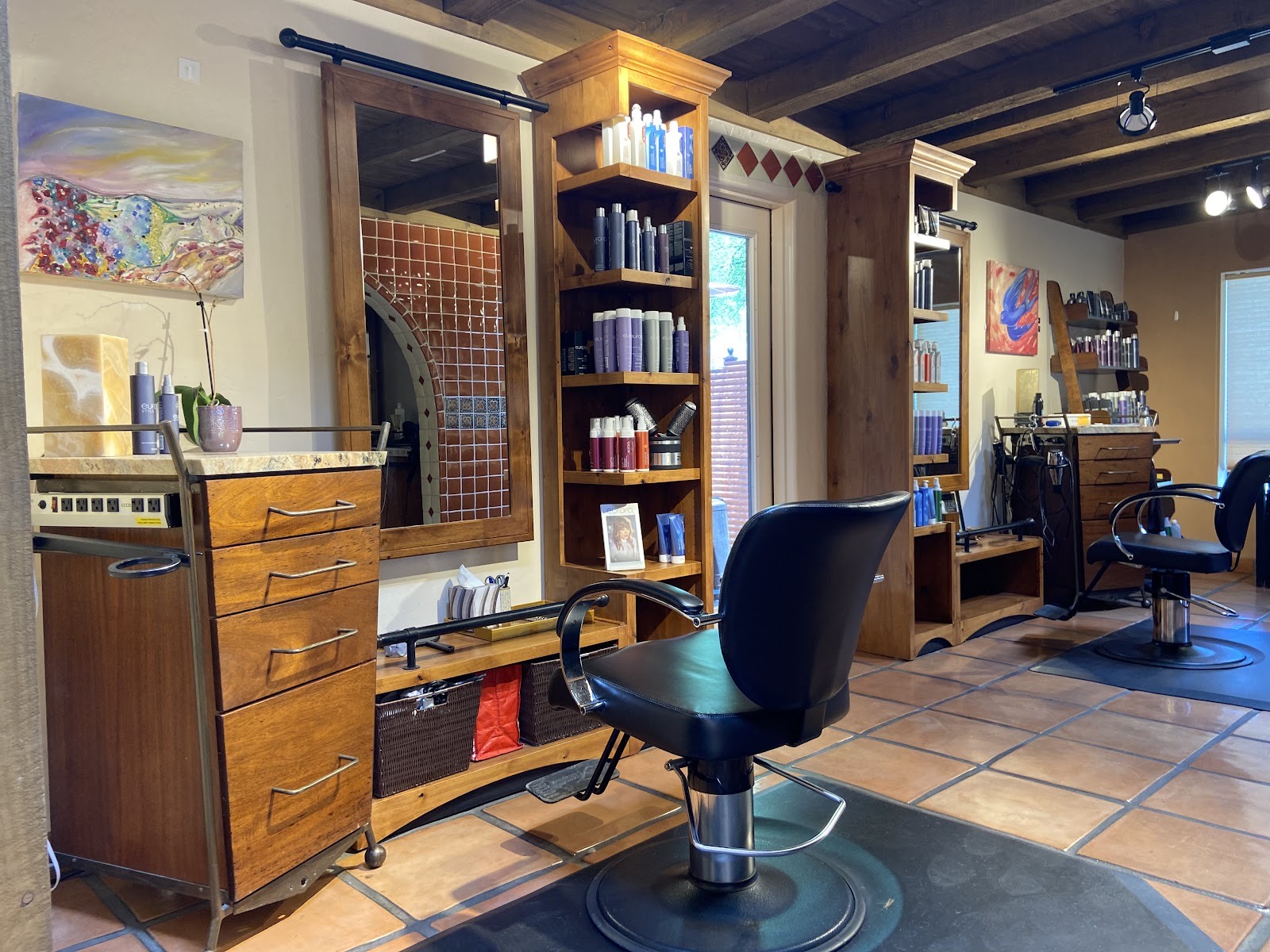 A styling chair and knotty-alder station inside Gloss Studio, with saltillo-tile floors and Eufora products on the shelves